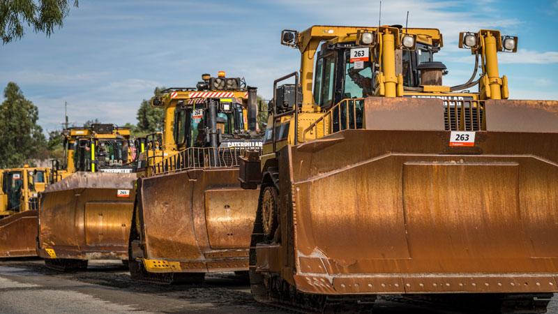 Four Caterpillar D9T bulldozers lined up.