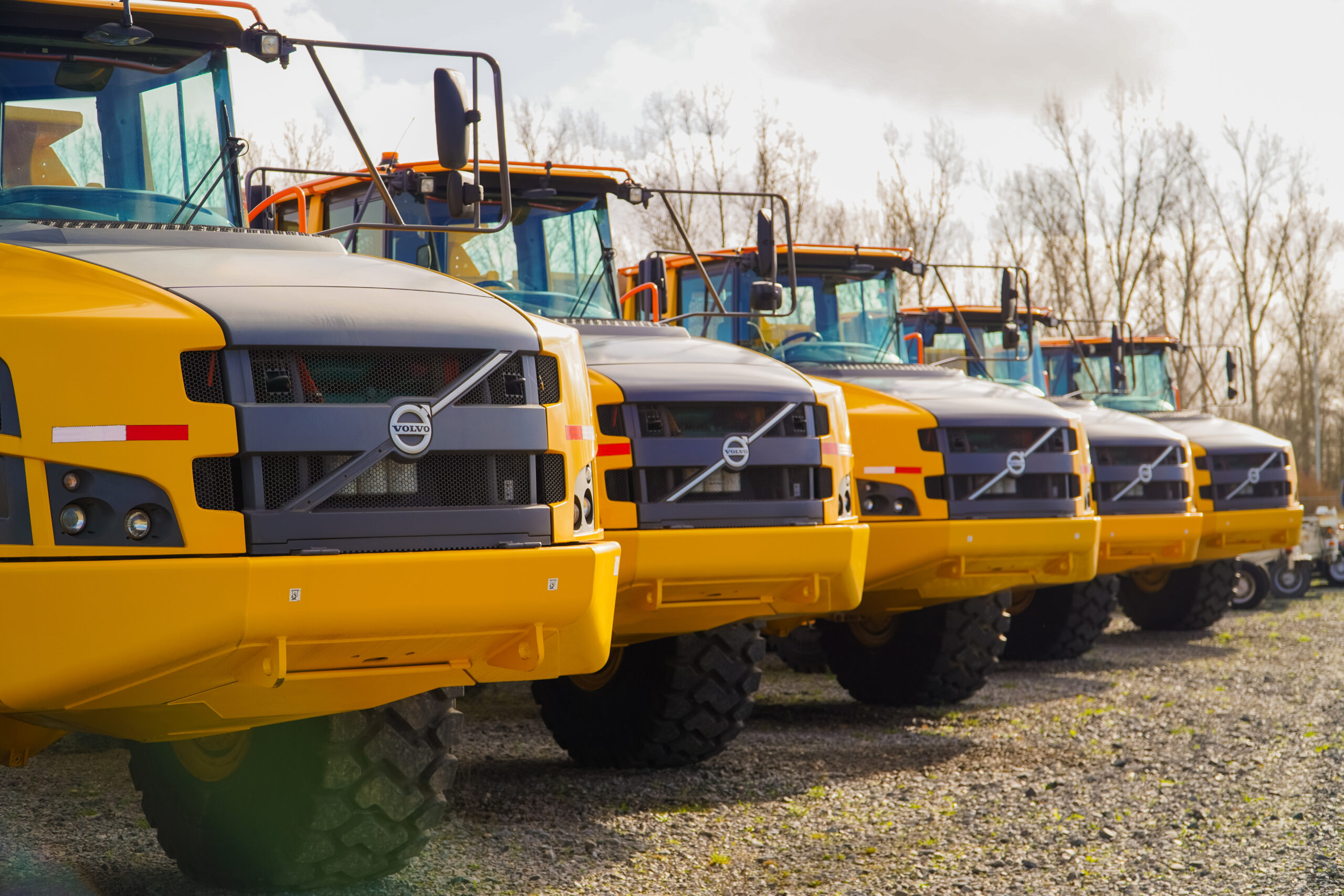 Five Volvo articulated haulers parked side by side.