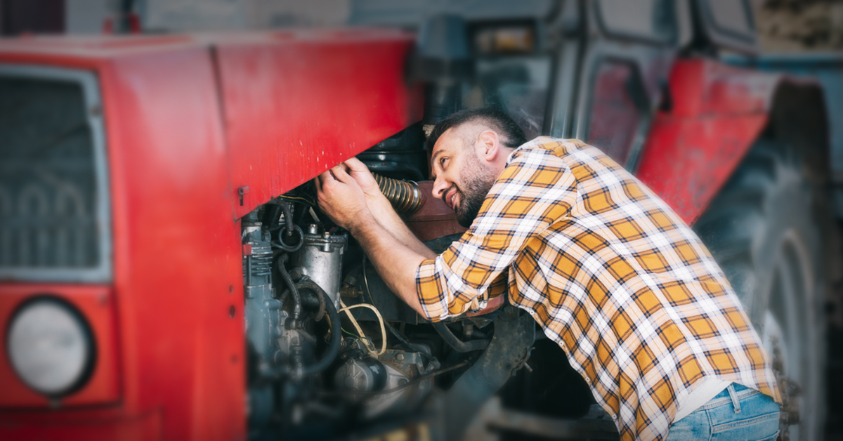 A mechanic is checking the engine of the heavy equipment.