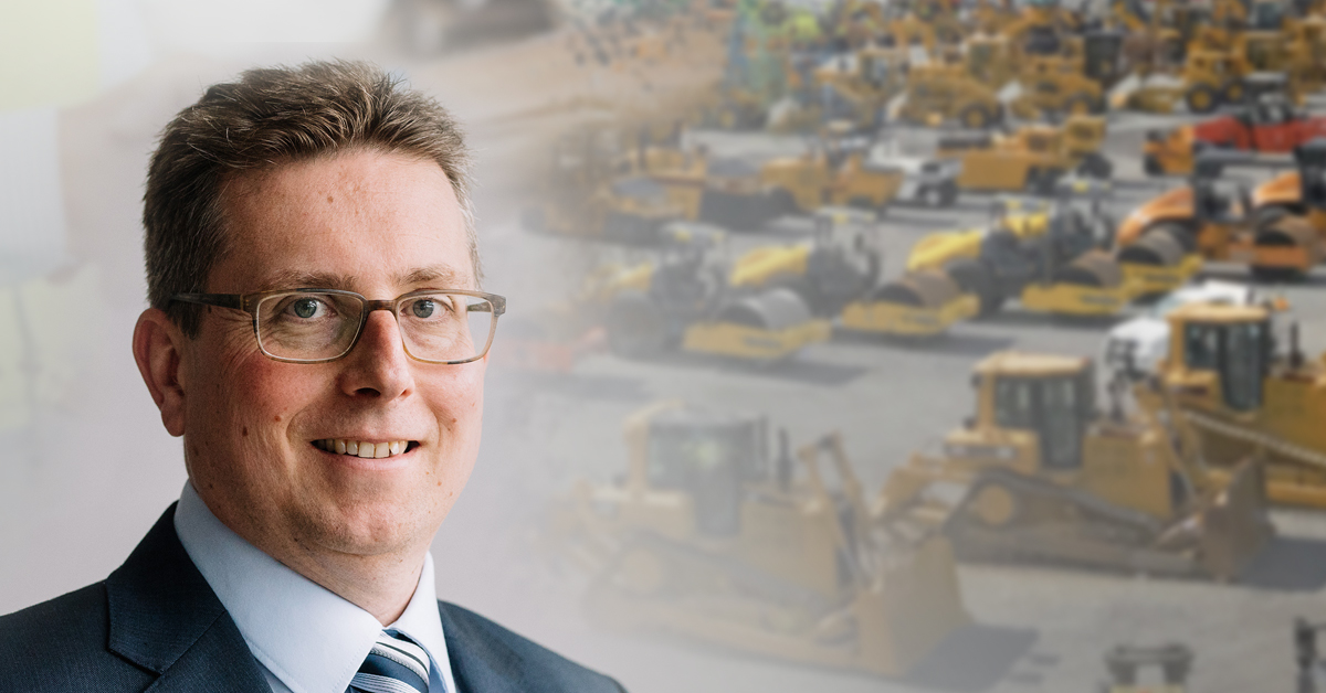 Chris Sleight, with several types of heavy equipment in the background.
