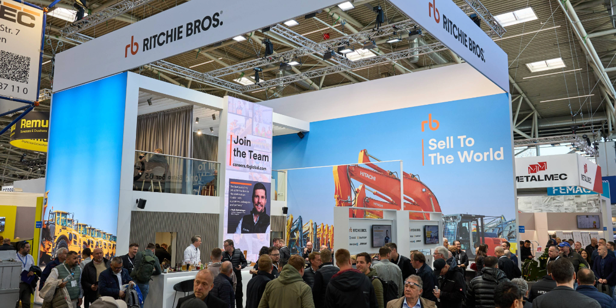 Ritchie Bros Booth at Bauma 2025 with heavy equipment in the photo